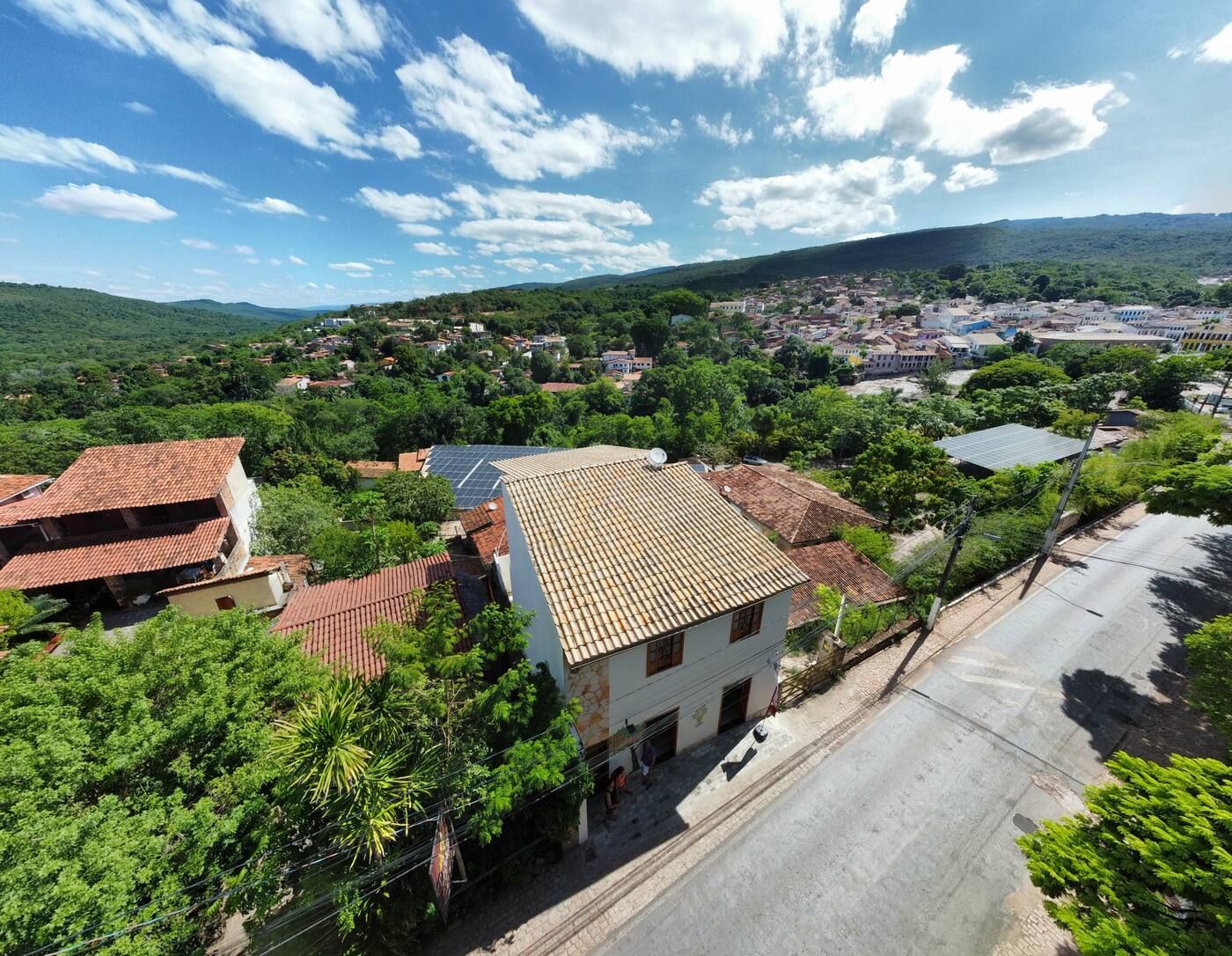 Vista aérea do prédio dos flats na avenida asfaltada de Lençóis, com a cidade e a serra ao fundo