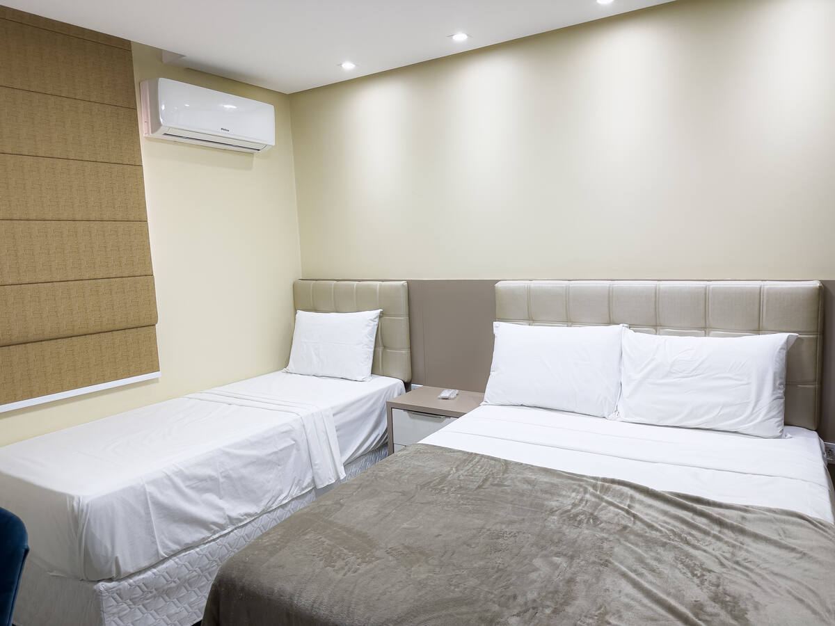 Suíte com cama de casal, cama de solteiro e ar-condicionado
